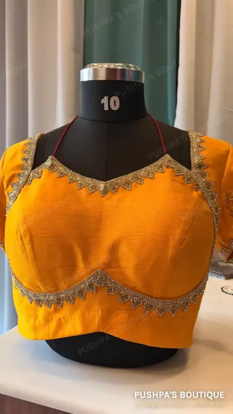 A mango-yellow princess cut blouse with pads and an even, machine-embroidered zari border along the neckline and under the bust