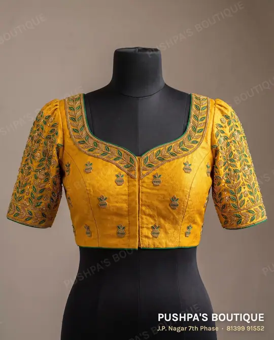 Turmeric-yellow designer blouse with aari work on the sweetheart neckline and sleeves