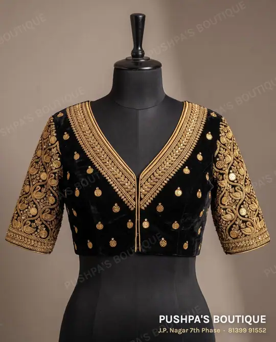 Black velvet designer blouse with a wide zari V neckline, kundan stones and embroidered elbow sleeves